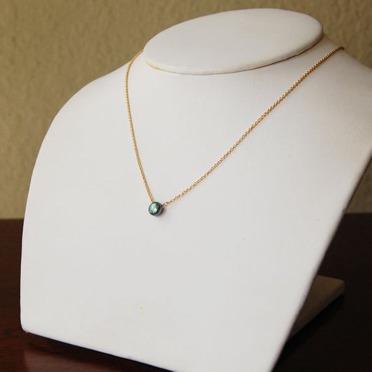 A grey pearl necklace on a white necklace bust. The chain is made from 14k gold filled and is delicate.